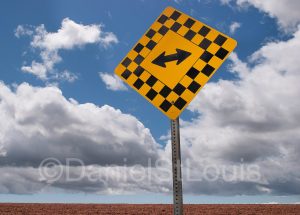 Both ways yellow sign on blue sky.